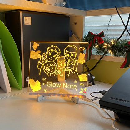 LED sign with family illustration on a desk next to a Lenovo laptop